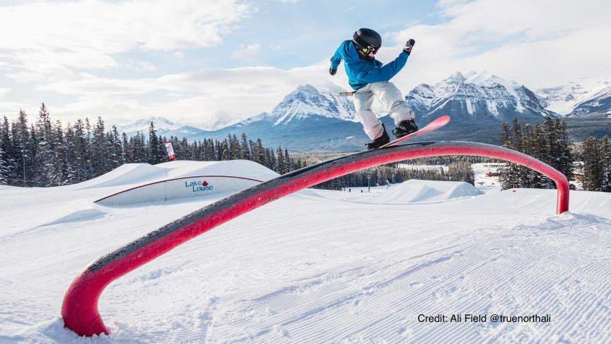 Stian riding a rainbow rail at Lake Louise